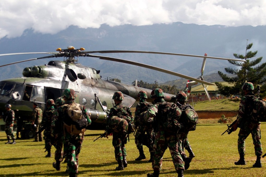Indonesian soldiers walk towards a helicopter headed for Nduga district in Papua province. Photo: Reuters