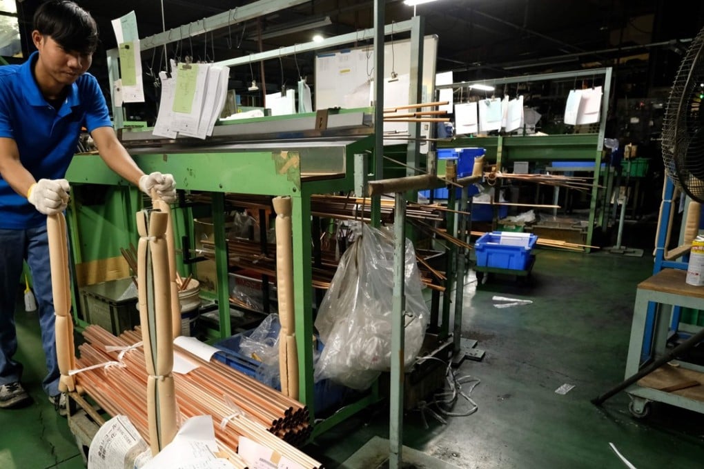 An Indonesian worker moving copper tubes at a factory in Oizumi, Gunma prefecture. Photo: AFP