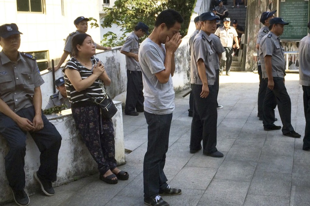 Parishioners pray in the courtyard of the Lower Dafei Catholic Church, in Yongjia County in Zhejiang Province, while Chinese government workers prepare to cut down the building’s cross in June 2015. A massive government campaign removed crosses from the spires, vaults, roofs and wall arches of the 4,000 or so Protestant and Catholic churches of the region. Photo: AP