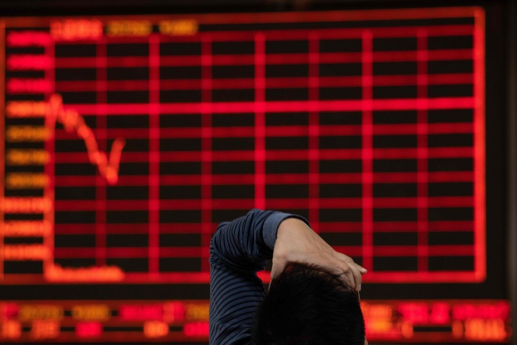 An investor gestures as he looks at stock price movements on a screen at a securities company in Beijing on October 12, 2018. Photo: AFP
