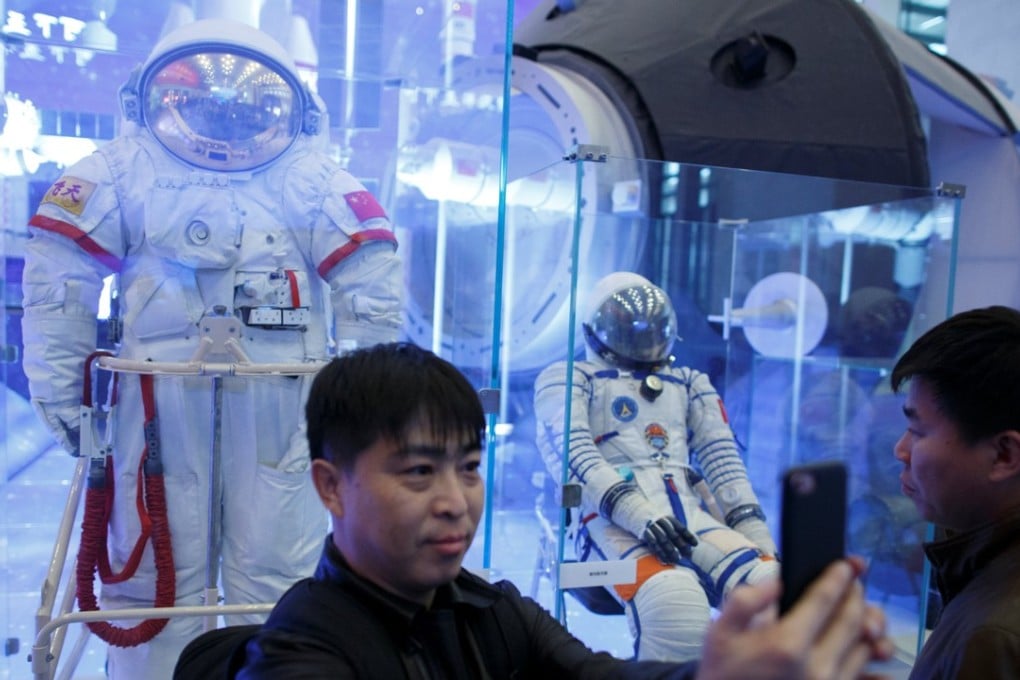 A visitor takes a selfie in front of a Chinese spacesuit at an exhibition at the National Museum of China in Beijing marking the 40th anniversary of China's reform and opening up. Photo: Reuters
