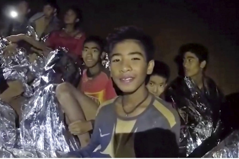 Boys trapped in the cave in Thailand smile as Thai Navy Seal doctors tend to their injuries before they were taken to safety. Photo: AP