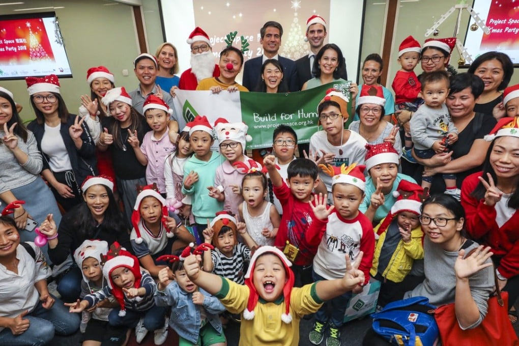 Carsten Stoehr and Liza Green from Credit Suisse join Project Space’s Christmas party at the charity’s Quarry Bay office, with children from families supported by Project Space. Photo: Felix Wong