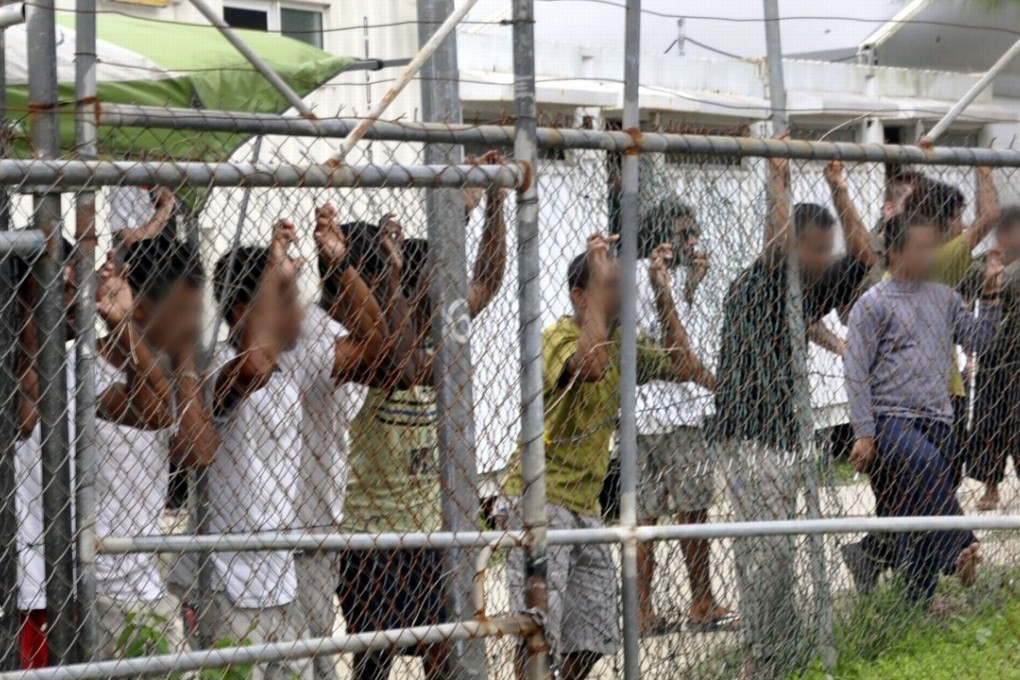 A 2014 file picture shows asylum seekers behind a fence at the Manus Island detention centre in Papua New Guinea. Photo: EPA