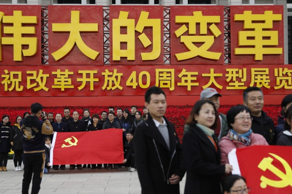 Chinese visitors hold the communist party flags for group photos outside an exhibition marking the 40th anniversary of China's reform and opening up at the National Museum of China, in Beijing, China, 15 November 2018. Photo: EPA-EFE
