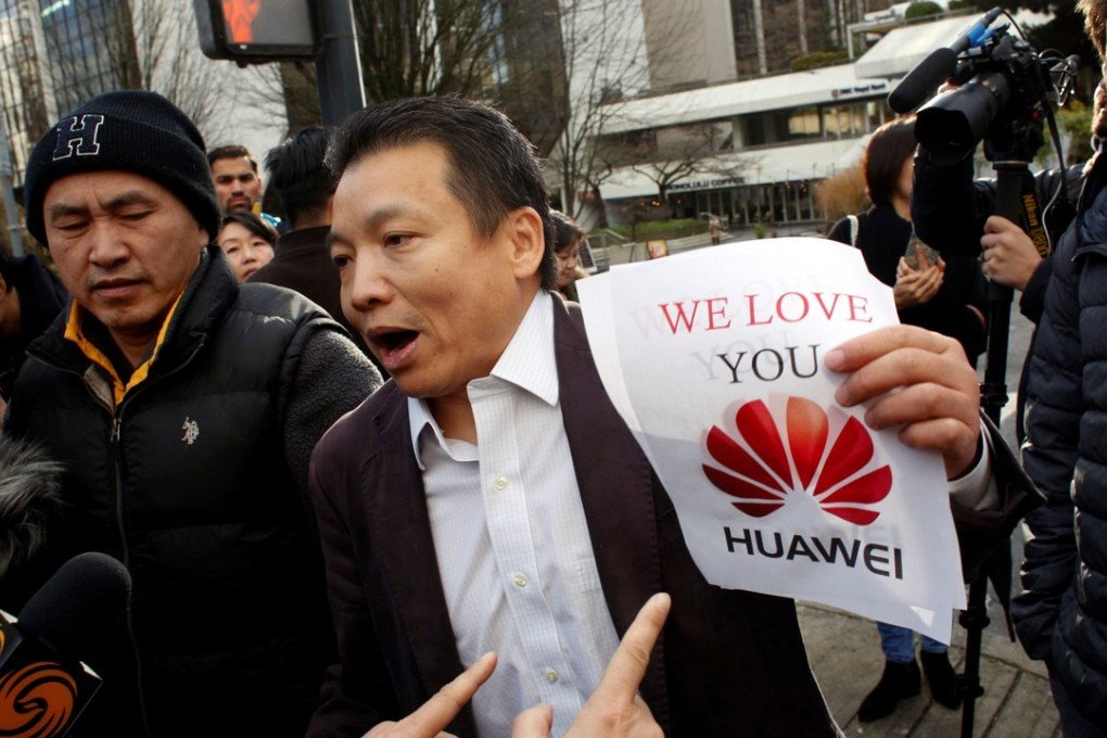 Joe Luo holding fliers he was handing out to supporters of Huawei CFO Sabrina Meng Wanzhou outside the Supreme Court in Vancouver, Canada on December 10, 2018. Photo: Reuters