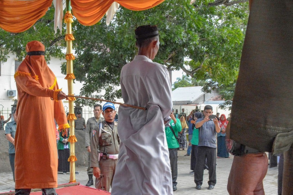 A man is whipped in front of a jeering crowd in East Aceh on December 11. Photo: AFP