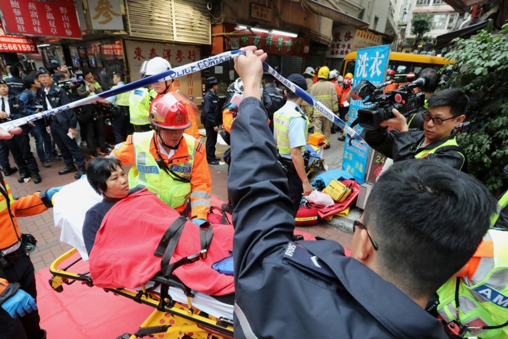 An injured pedestrian is carried away from the scene of the school bus crash in North Point. Photo: Felix Wong