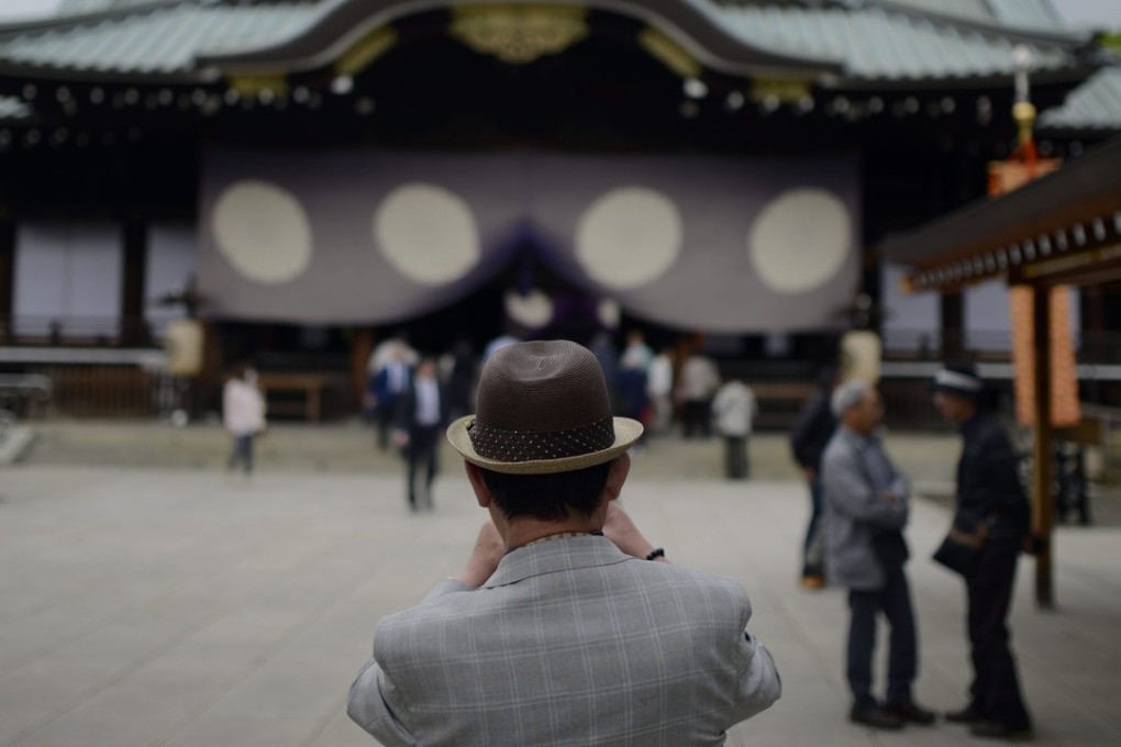 An elderly visitor takes pictures at the Yasukuni Shrine in Tokyo. Photo: EPA
