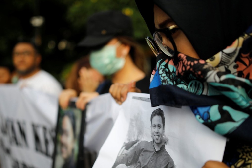 A woman holds a picture of a relative killed in the Lion Air crash during a rally in Jakarta. Photo: Reuters