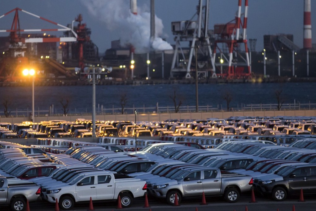 Toyota pickup trucks bound for shipment in a lot at night at the port in Nagoya. Photo: Bloomberg