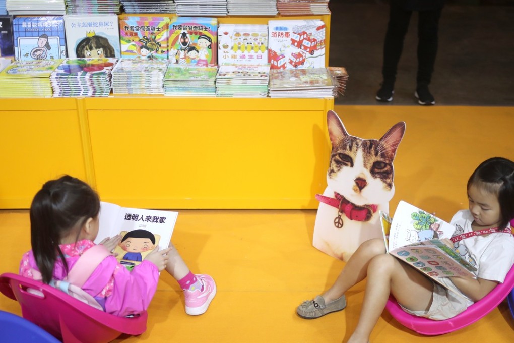 Children read at a booth at the Hong Kong Book Fair, at the Hong Kong Exhibition and Convention Centre in July. Photo: Winson Wong