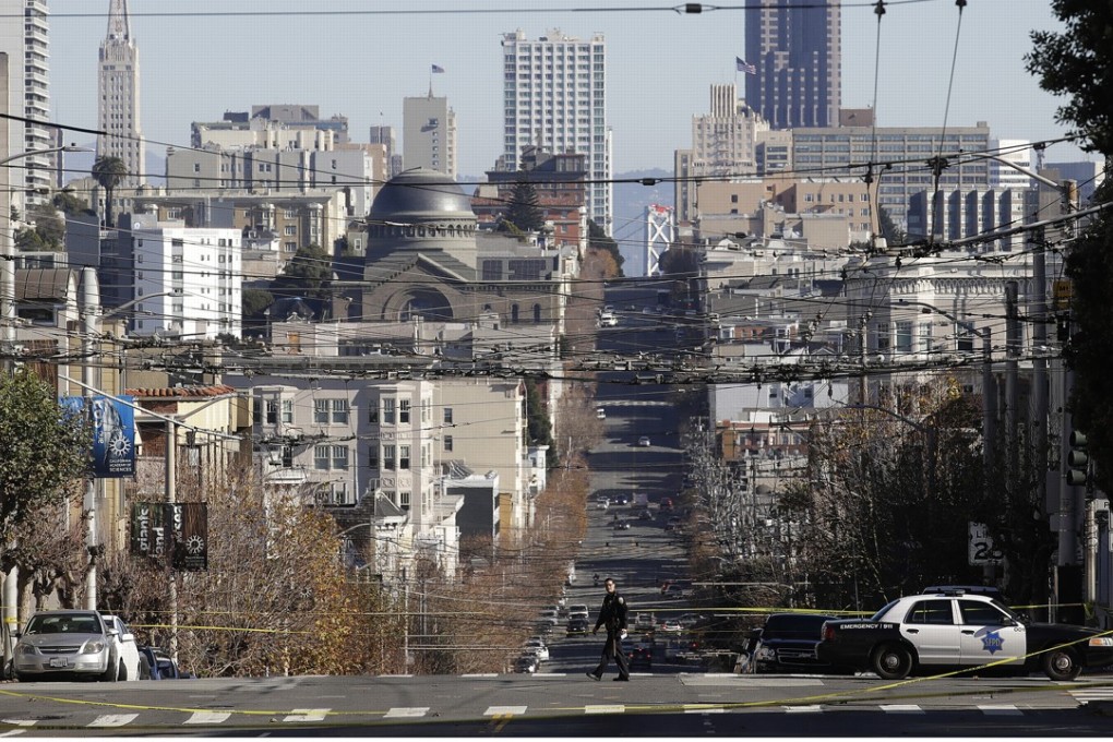 A police officer walks in an intersection closed off by police tape on California Street in San Francisco on December 13, 2018, after an emailed bomb threat that turned out to be a hoax. Photo: AP