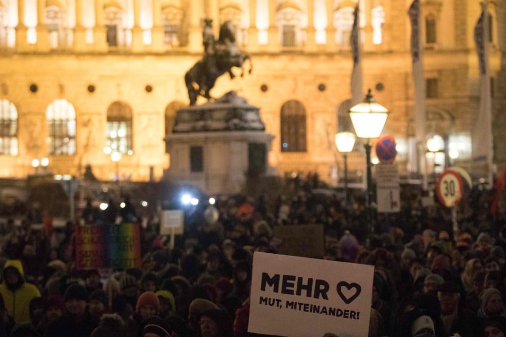 A demonstrator holds a sign reading ‘More heart,courage, cooperation’ in front of the Vienna Hofburg at Heldenplatz during a demonstration a year after the formation of a government by the Conservative Oevp - FPOe on December 15, 2018 in Vienna. Photo: AFP