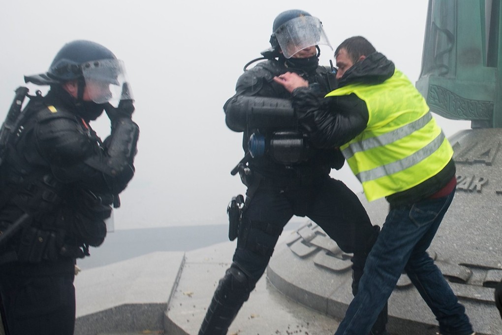 French riot police clash with a protester wearing a yellow vest as they protest against rising costs of living they blame on high taxes in Nantes, on December 15, 2018. – The “Yellow Vests” (Gilets Jaunes) movement in France originally started as a protest about planned fuel hikes but has morphed into a mass protest against President's policies and top-down style of governing. Photo: AFP