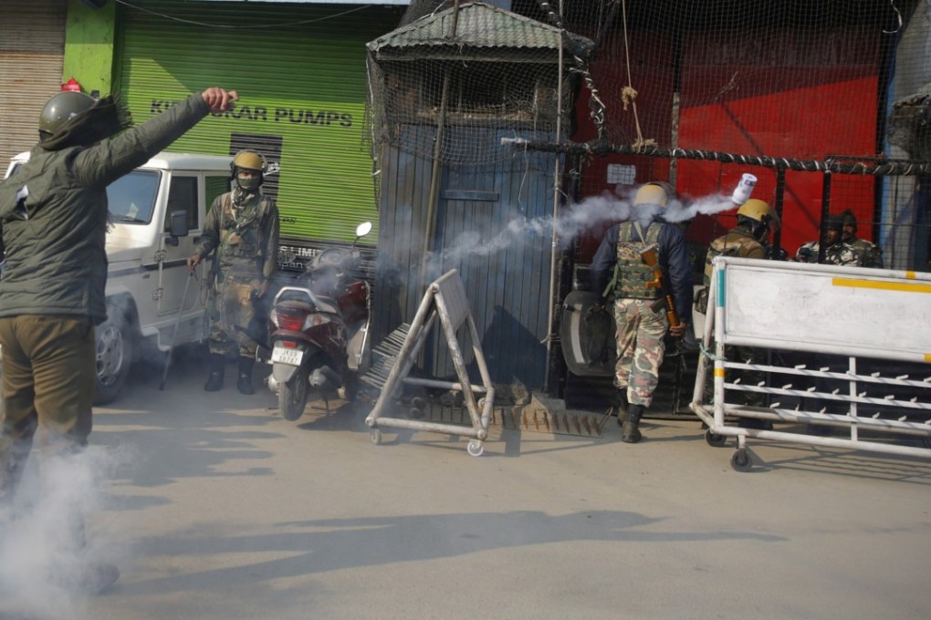 An Indian police officer throws a tear-gas canister towards supporters of Jammu and Kashmir Liberation Front (JKLF) during a protest in Srinagar on December 17, 2018. Photo: EPA