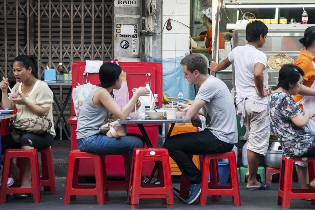 Tourists eat food on the main street of Chinatown in Bangkok. Photo: Shutterstock