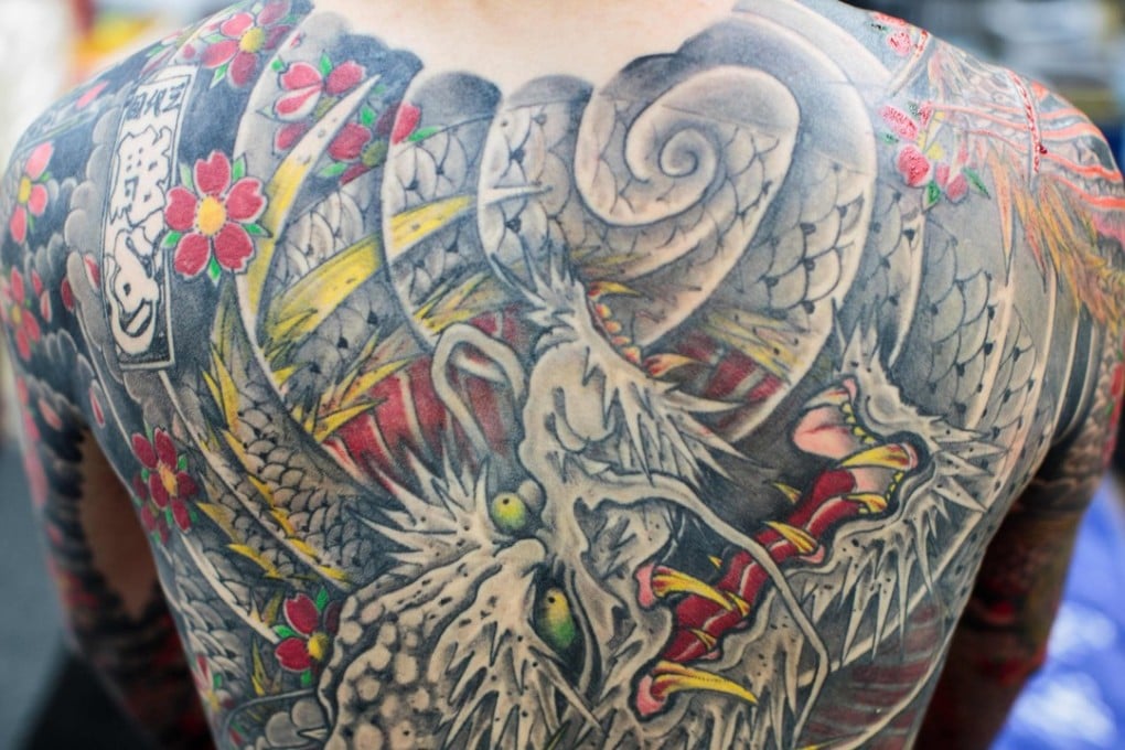 Japanese “salaryman” Kyono displays his tattoos as he poses for a photo in Yokohama. Photo: AFP