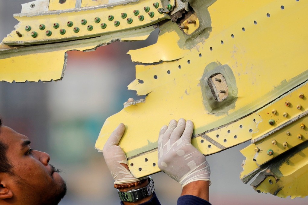 An Indonesian official carries debris from the crashed Lion Air flight JT610. Photo: Reuters
