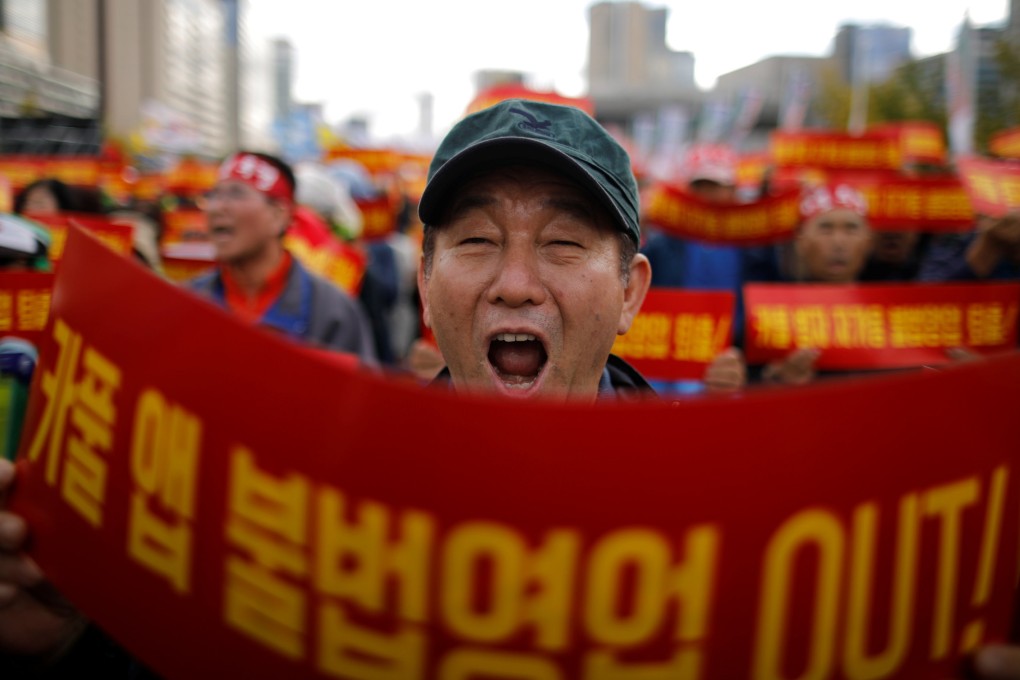 A taxi driver takes part in a protest against a carpool service application that will be launched by Kakao Corp later this year, in central Seoul, South Korea, October 18, 2018. The banners read, “Stop carpool service application, it is illegal business”. Photo: Reuters