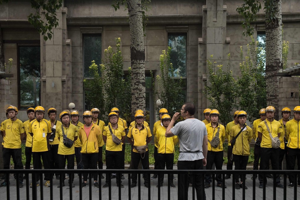 This file picture shows Meituan food delivery workers attending a morning briefing in Beijing. Photo: AFP