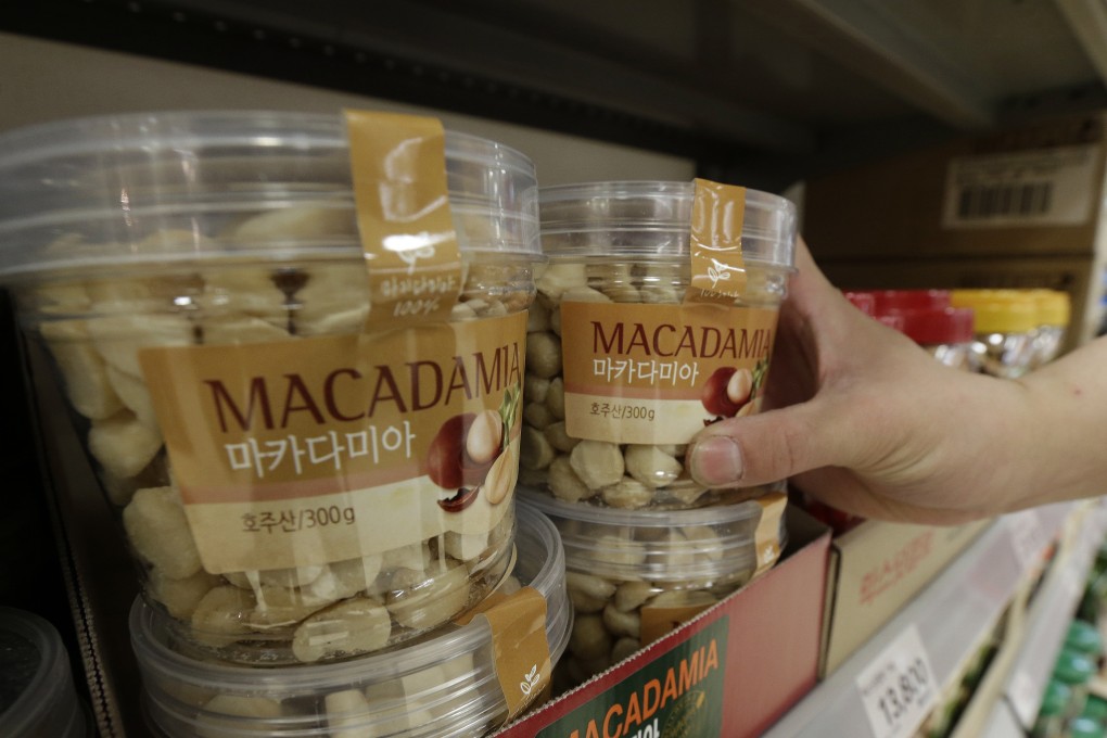 A customer picks up a plastic container of Macadamia nuts at a store in Seoul. Photo: AP