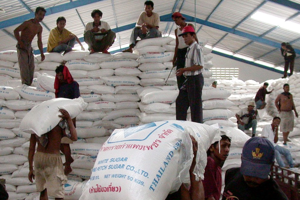 Indonesian workers unload imported sugar in Semarang. Photo: AFP