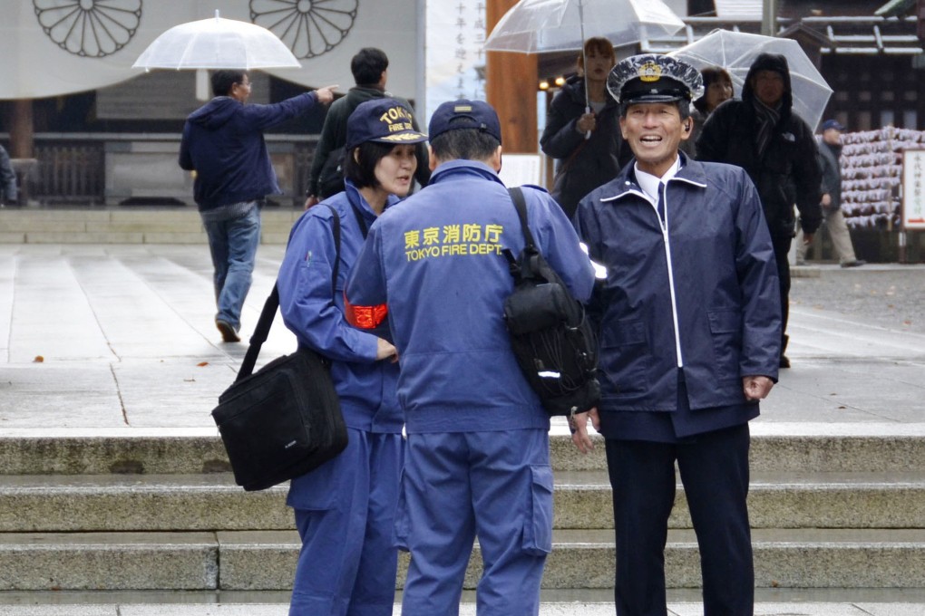 Japanese fire department personnel at Yasukuni Shrine in Tokyo after two Hong Kong activists were arrested over a protest. Photo: Kyodo News via AP