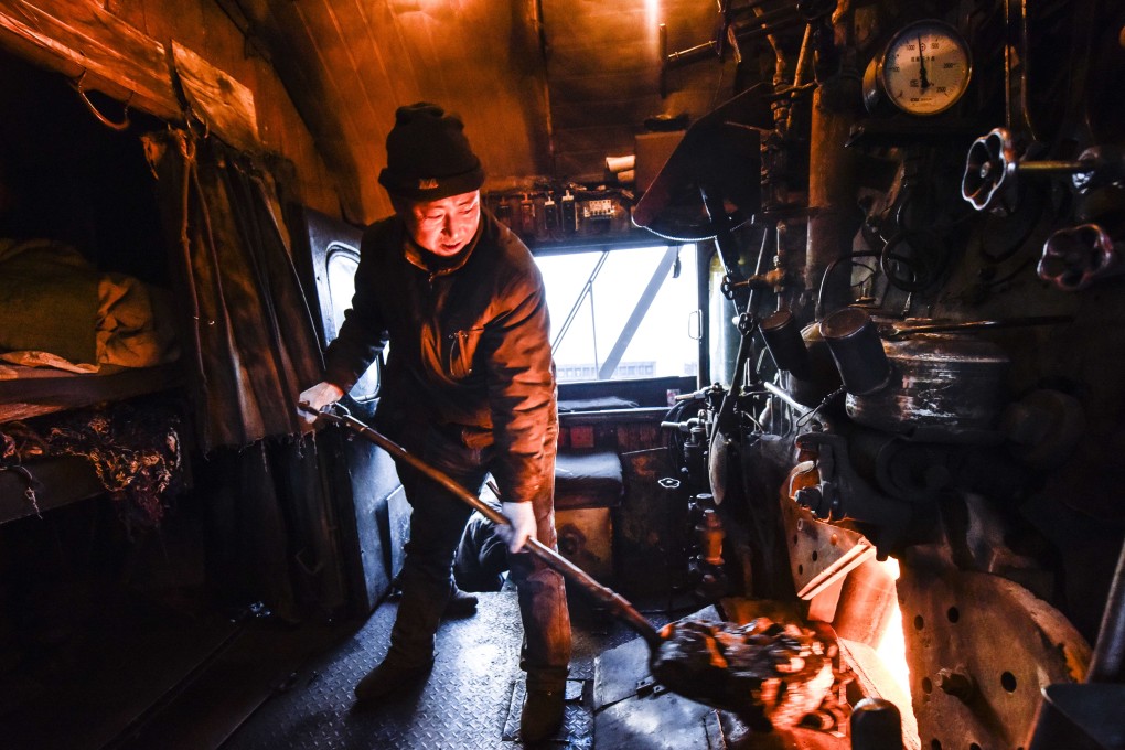 Stoker Dai Yanjia adds coals to a steam locomotive boiler at Sandaoling coal mine area in Hami, in China’s Xinjiang Uygur autonomous region, in January. Photo: Xinhua