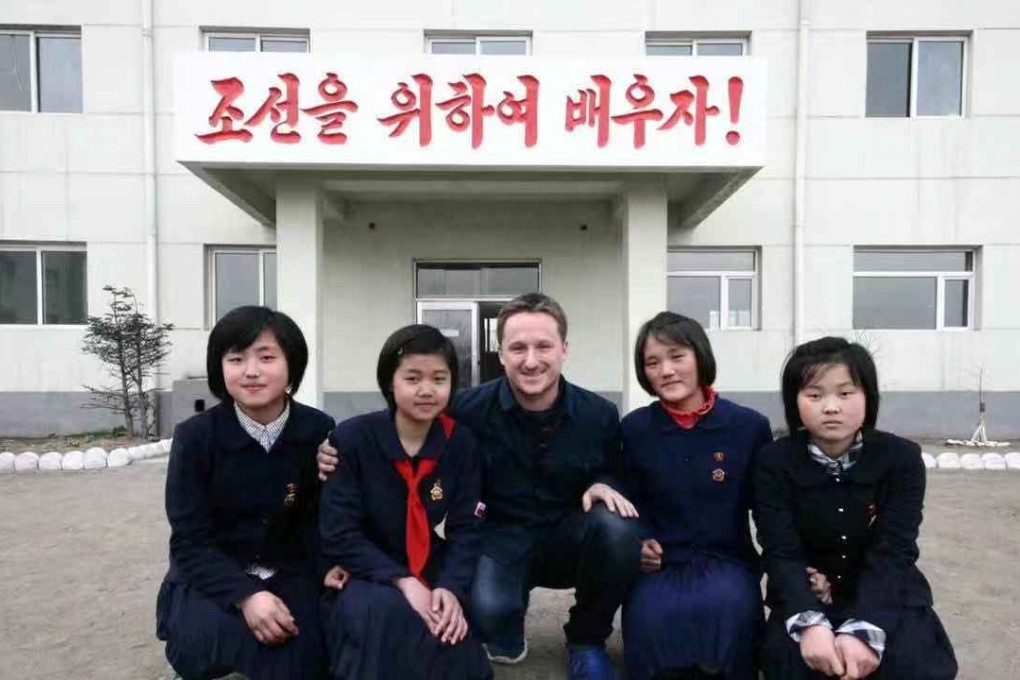 Canadian businessman Michael Spavor poses with girls at a school in North Korea. The characters read: “Let’s study for Korea!” Photo: Reuters