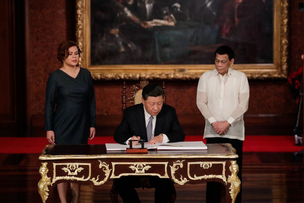 Visiting Chinese President Xi Jinping signs the guest book as Philippine President Rodrigo Duterte and his daughter Sarah look on at the Malacanang Presidential Palace in Manila on November 20. Philippine domestic politics is increasingly racked by a polarising debate over its policy towards China, particularly its claims in the South China Sea. Photo: AFP