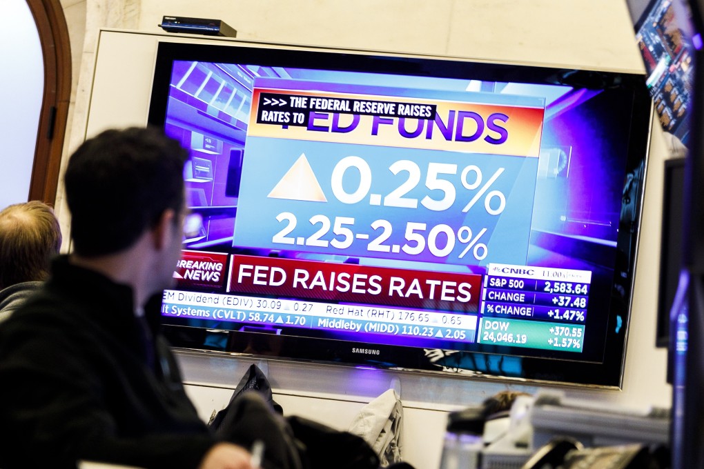 Traders watch news reports about the US Federal Reserve's decision to raise interest rates, from on the floor of the New York Stock Exchange on Wednesday. Photo: EPA