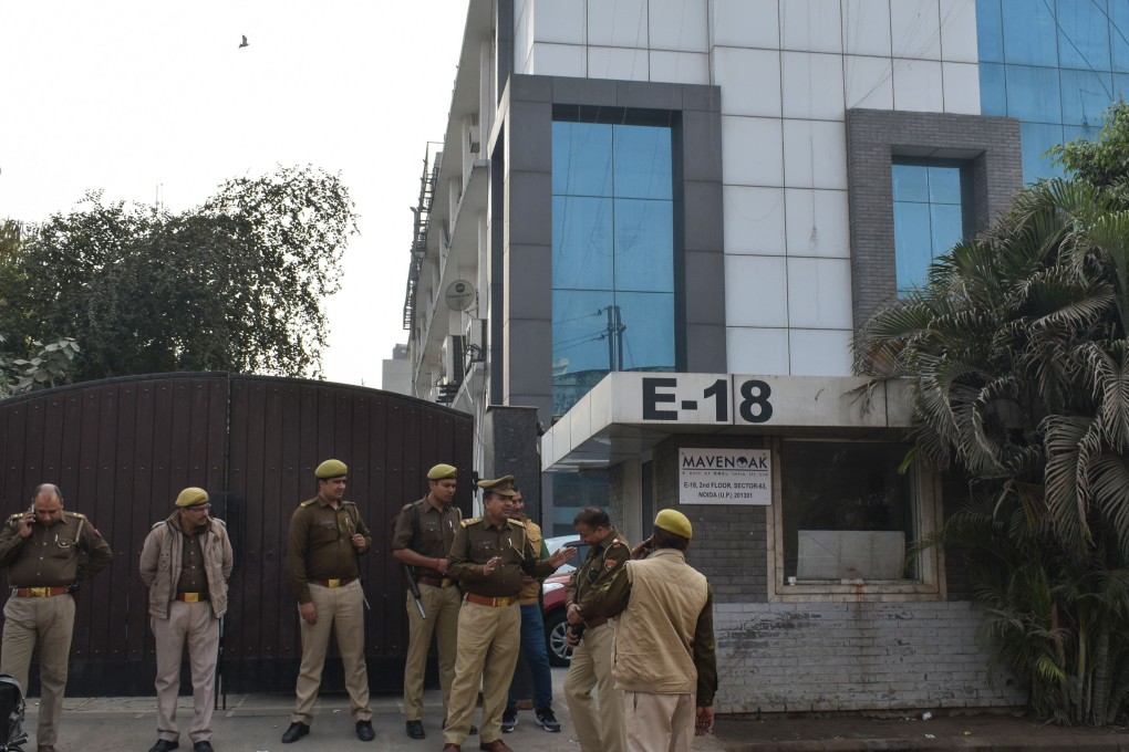Indian police personnel wait outside the office of the alleged fake call centre in Noida. Photo: AFP