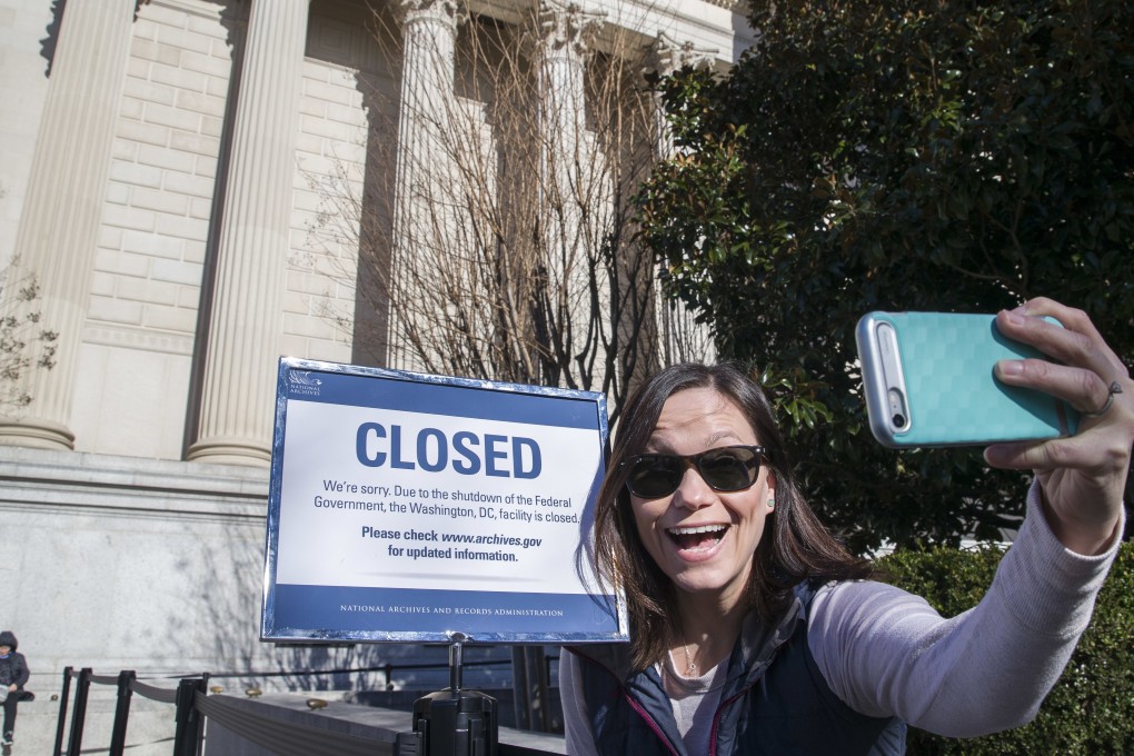Jamie Parrish, from Minneapolis, takes a selfie in front of the closed sign at the National Archives, Saturday, December 22, 2018 in Washington. The House and Senate are gavelling back in for a rare weekend session amid a partial government shutdown over President Donald Trump’s demand for billions of dollars for a border wall. Photo: AP Photo