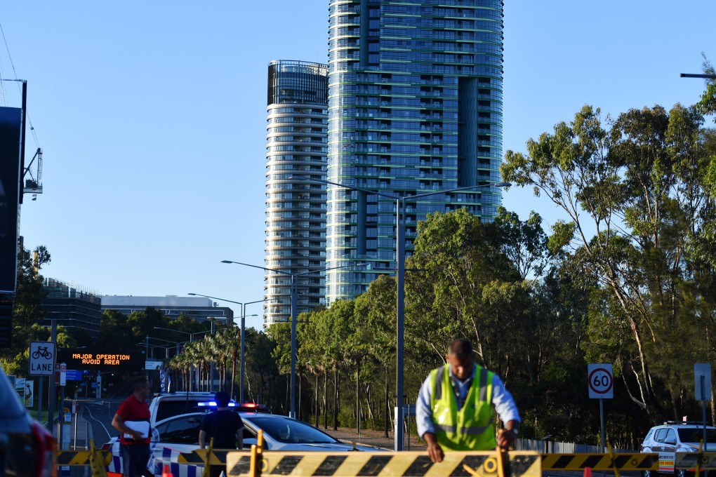Authorities cordon off a street leading to the Opal Tower at Sydney Olympic Park. Photo: EPA