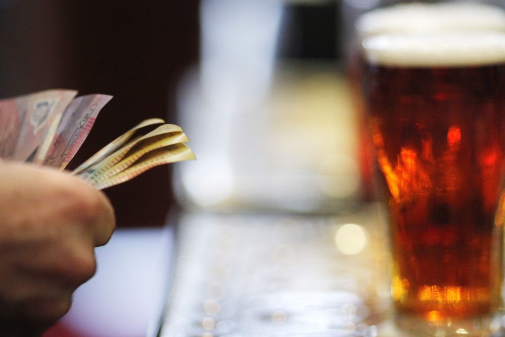 A customer pays for a beer using cash. Photo: Reuters
