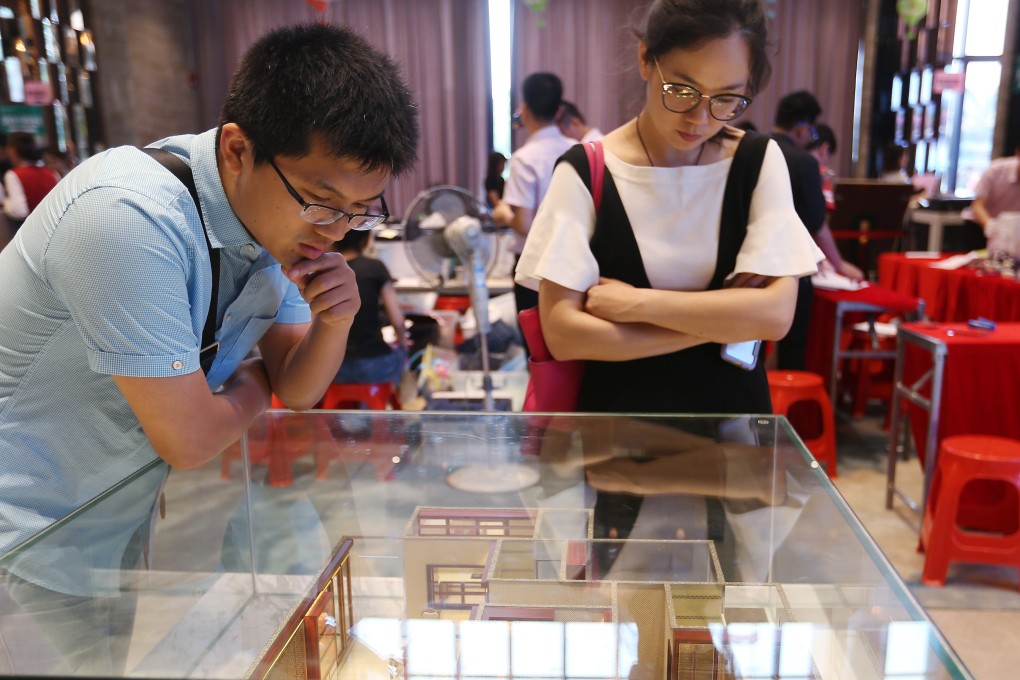 A couple at a property sales centre in Guangzhou. Analysts are convinced more cities will follow Guangzhou and Zhuhai in scrapping ‘non-critical’ restrictive measures. Photo: Xiaomei Chen