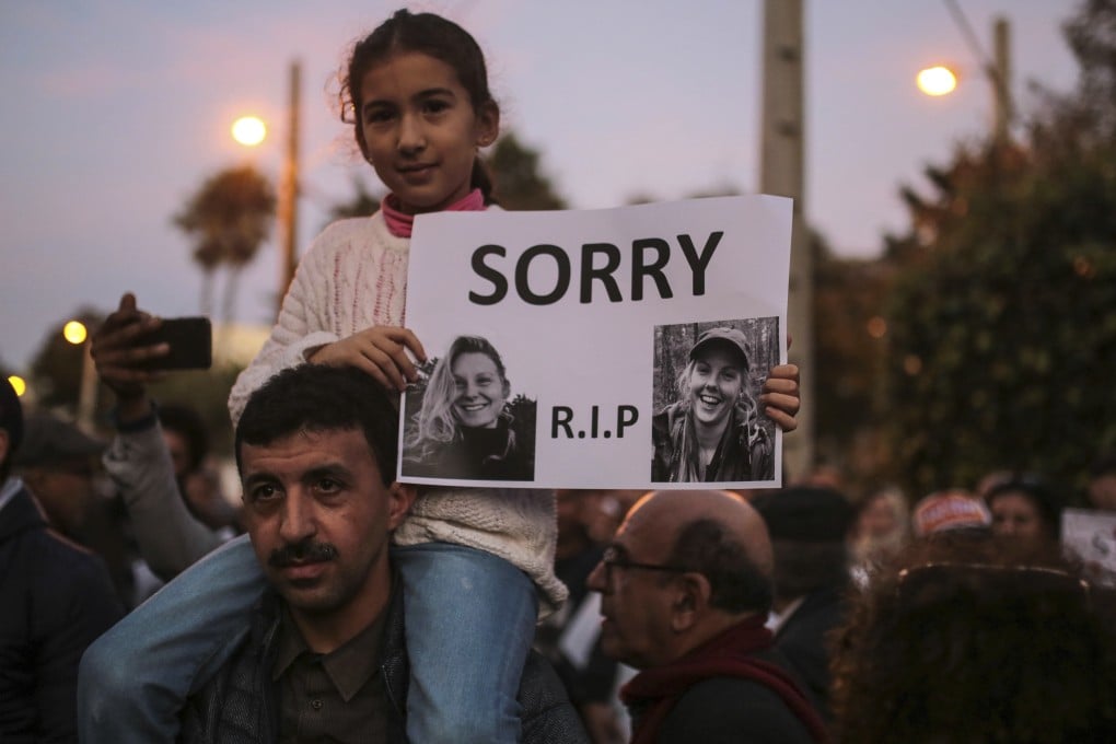 A girl carries pictures of 24-year-old Dane Louisa Vesterager Jespersen (left) and 28-year-old Norwegian Maren Ueland during a candlelight vigil outside the Danish embassy in Rabat, Morocco, on Saturday. Photo: AP