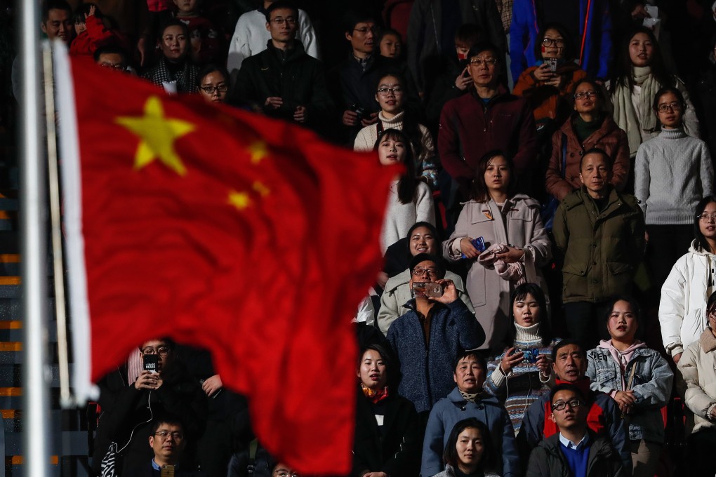 Chinese citizens look at their flag as they sing their national anthem during the opening ceremony of the FINA Swimming Short Course World Championships in Hangzhou on December 11. Photo: EPA-EFE