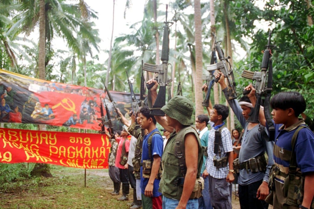 New People's Army guerillas raise their firearms to mark a previous anniversary in 1998. Photo: AP