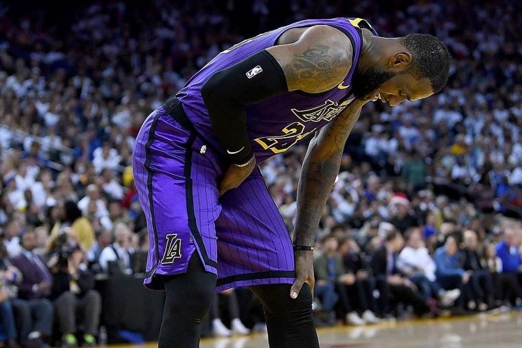 LeBron James leans over in pain after he was hurt against the Golden State Warriors. Photo: AFP