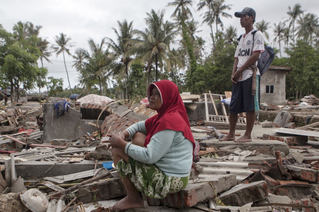 An Indonesian tsunami victim sits on the ruins of her house after a tsunami hit the Sunda Strait, in Paniis Village, Pandeglang, Banten. Photo: EPA