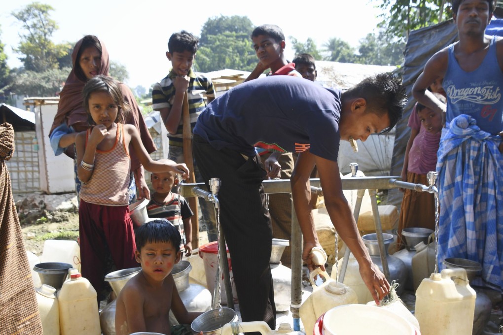 Rohingya Muslims fill water containers at a refugee camp in Cox's Bazar. Photo: Kyodo