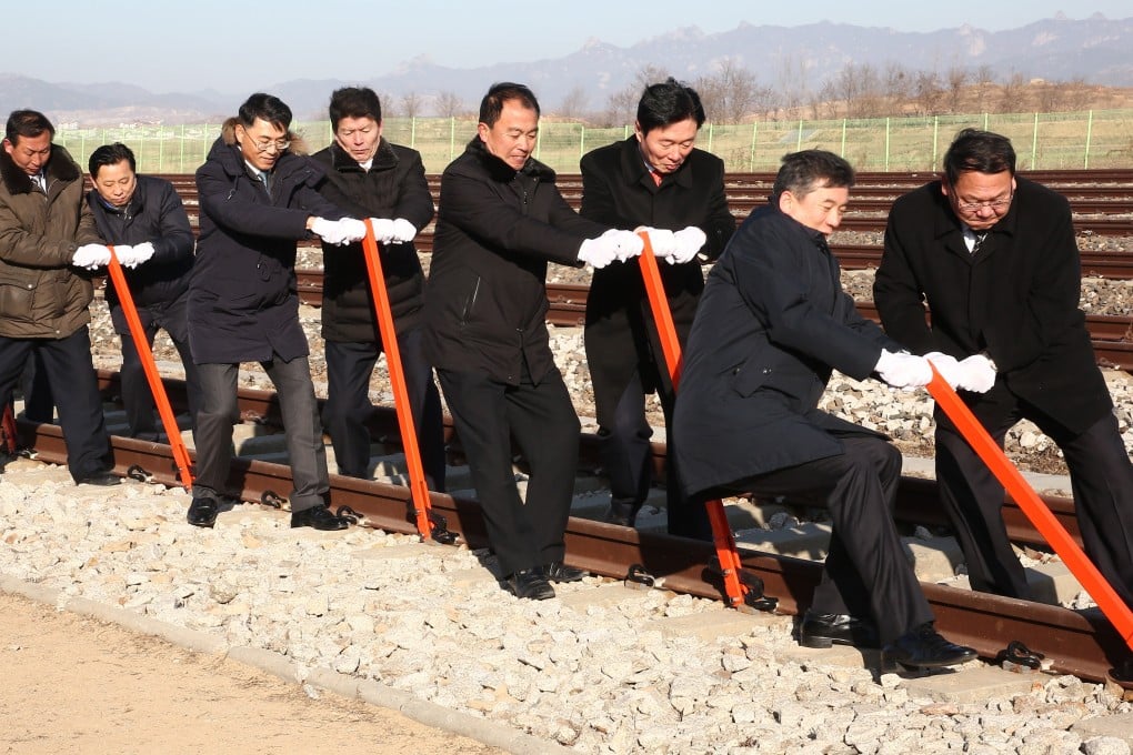 South and North Korean government officials connect northern and southern railroad tracks during a groundbreaking ceremomy. Photo: EPA