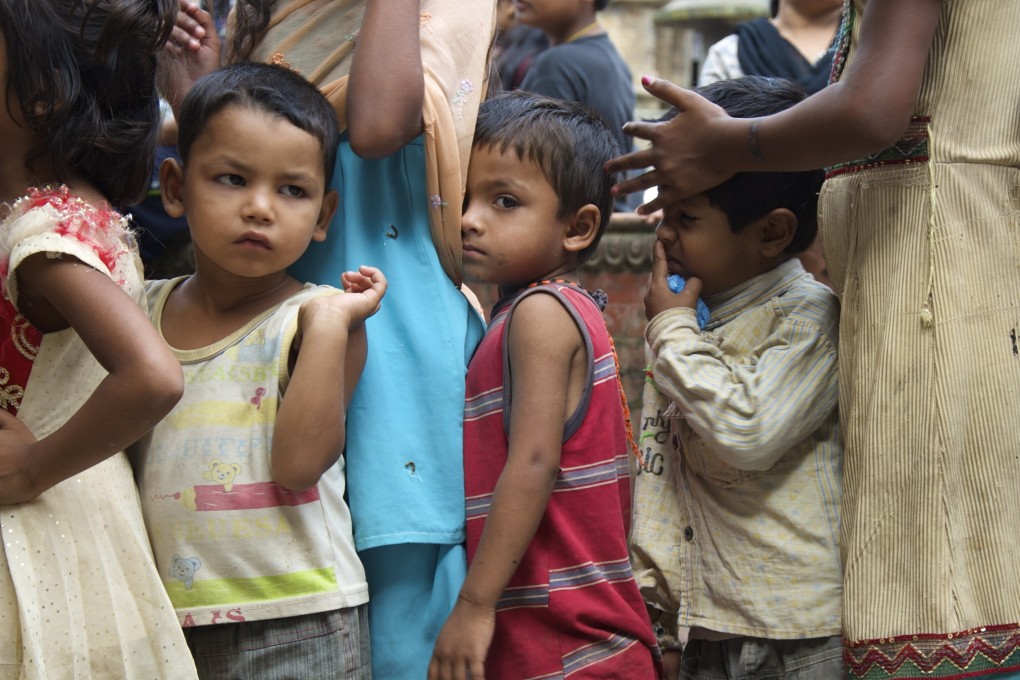 Orphaned children in Nepal line up for a meal.