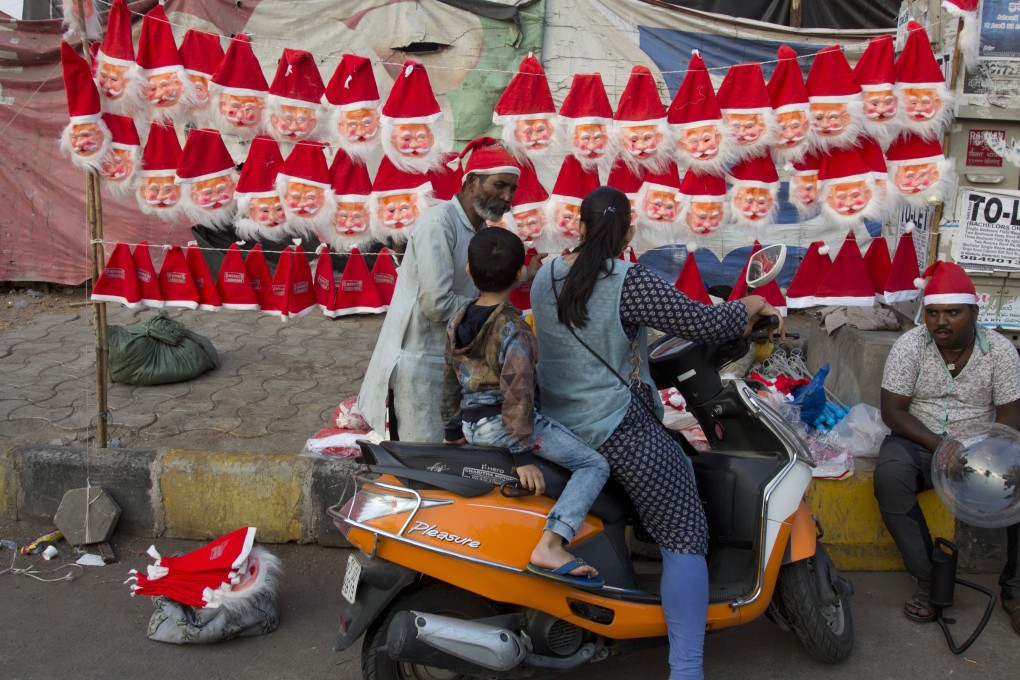 Indian vendors sell Santa Claus masks and caps on a street in Hyderabad, India. Photo: AP