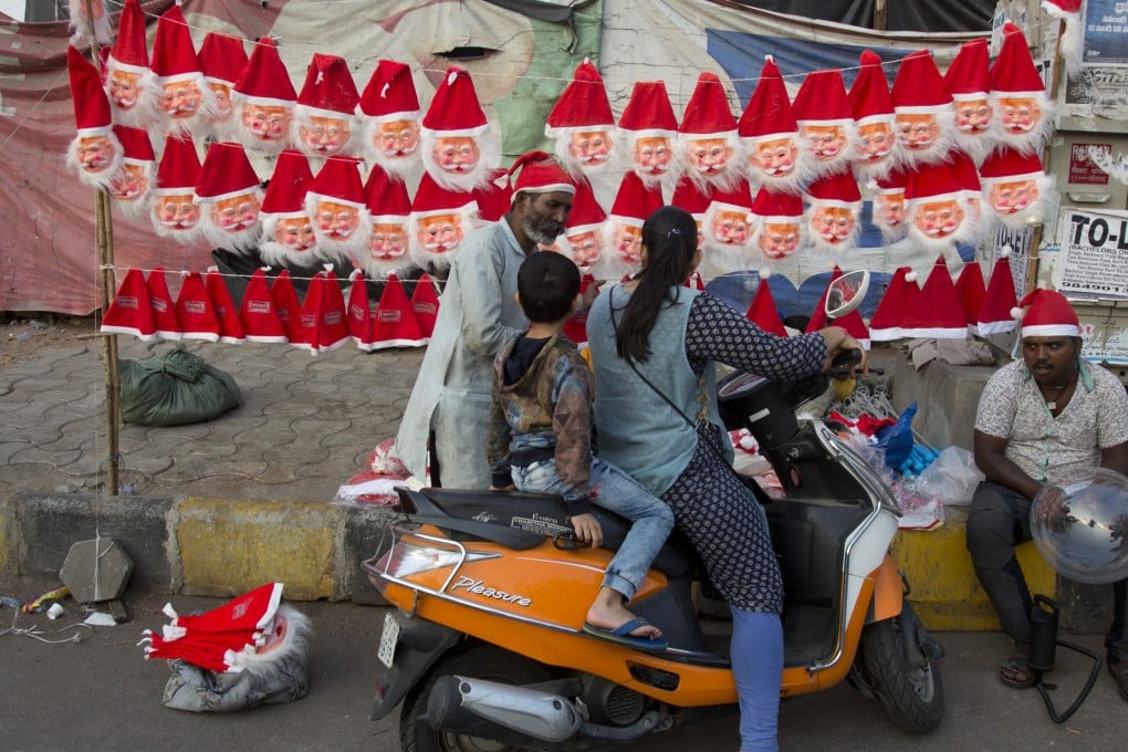 Indian vendors sell Santa Claus masks and caps on a street in Hyderabad, India. Photo: AP
