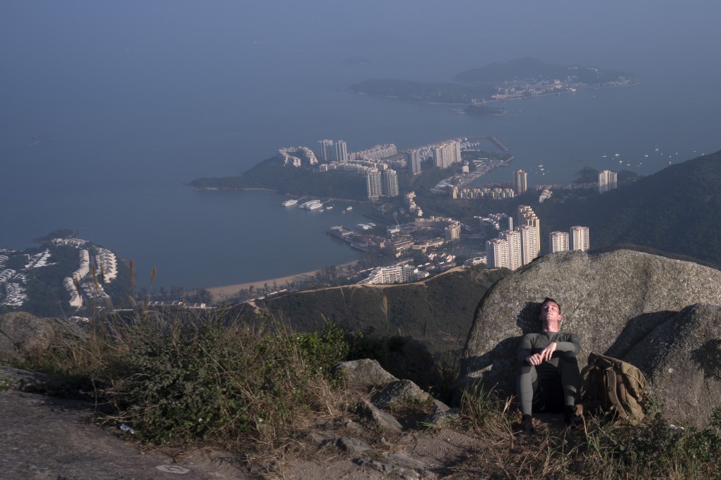 A hiker rests atop a rock on Tiger’s Head (Lo Fu Tau) in Lantau North Country Park. Behind him lie Discovery Bay and Peng Chau island. Photo: Robert Ng