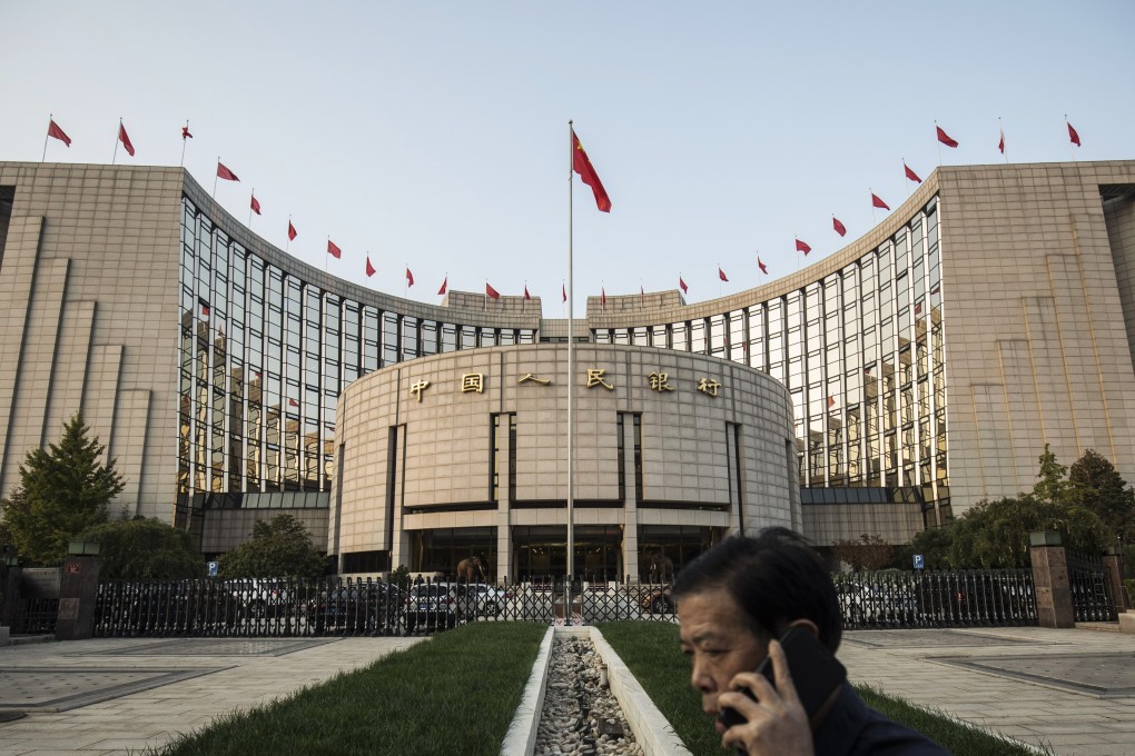 A man talks on a mobile phone outside the People's Bank of China headquarters in Beijing, China. China's central bank is said to have gauged demand for 63-day reverse repurchase agreements for the first time ever. Photo: Bloomberg