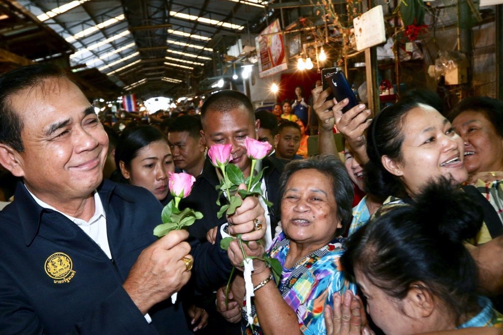 Thai junta leader Prayuth Chan-ocha receives flowers from supporters. Photo: EPA